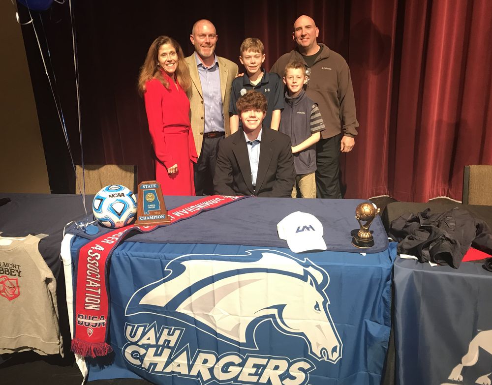 Family celebrating at a college soccer signing table