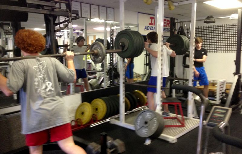 Athletes squatting in power racks
