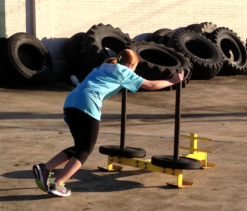 Young athlete doing a sled push